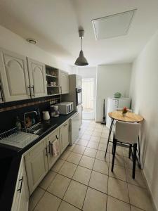 a kitchen with white cabinets and a table in it at Appartement plein centre du puy en velay avec parking in Le Puy en Velay +11 photos