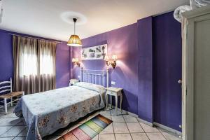 1 dormitorio con paredes de color púrpura y 1 cama en Prado del abuelo, en Cabezuela del Valle 37 fotos más