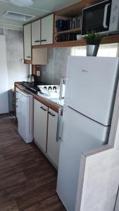 a kitchen with a white refrigerator and wooden cabinets at Śniegocinka 4 in Brenna