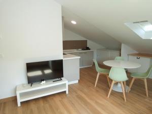 a living room with a table and chairs and a kitchen at Mar de Queiruga 21 Enxa in Porto do Son +32 photos