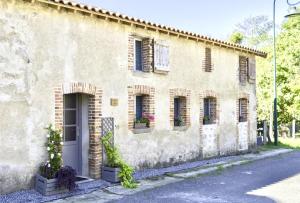 a stone building with a door and windows at Petite Maison de Mouton in Azat-le-Riz