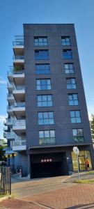 een groot zwart gebouw met veel ramen bij AK Apartamenty Centrum in Białystok