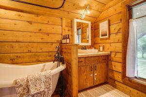 a bathroom with a tub and sink in a log cabin at Picturesque Lake Elmo Cottage with Fire Pits! in Lake Elmo