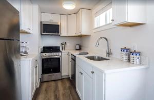 a kitchen with white cabinets and a stainless steel appliance at Serene Condo for Cozy Cape Getaway in Truro