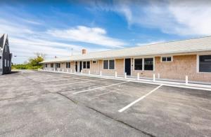 an empty parking lot in front of a building at Serene Condo for Cozy Cape Getaway in Truro