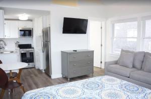 トゥルーロにあるFresh and Crisp Pet Friendly Studioのリビングルーム(ベッド1台、ソファ付)、キッチンが備わります。