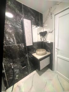 een badkamer met een wastafel en een spiegel bij Apartotel bleqs in Batoemi