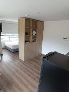 a bedroom with a bed and a tv in a room at Comodo Loft con vista al Skyline de Bogotá in Bogotá +2 photos