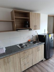 a kitchen with a sink and a refrigerator at Comodo Loft con vista al Skyline de Bogotá in Bogotá