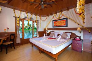 a bedroom with a large bed in a room at Abad Premium House Boat in Kumarakom