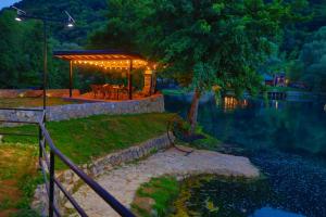 a gazebo sitting next to a lake at night at Holiday Homes Mujo Bejzin in Račić