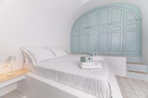 a white bedroom with a large bed with a blue headboard at Blue Vine Villa - Private Pool - Panoramic Sea View in Kamari