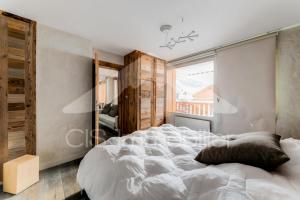 a bedroom with a large white bed and a window at Chalet De Meribel - Magnifique appartement 6 pièces pour 10 personnes dans le centre de Méribel proche des commerces et des pistes de ski MAE-1653 in Les Allues