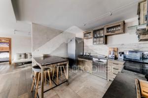a kitchen with a table and some chairs in it at Chalet De Meribel - Magnifique appartement 6 pièces pour 10 personnes dans le centre de Méribel proche des commerces et des pistes de ski MAE-1653 in Les Allues