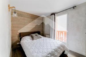 a bedroom with a white bed and a window at Chalet De Meribel - Magnifique appartement 6 pièces pour 10 personnes dans le centre de Méribel proche des commerces et des pistes de ski MAE-1653 in Les Allues +8 photos
