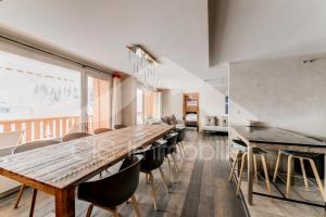 a dining room with a long wooden table and chairs at Chalet De Meribel - Magnifique appartement 6 pièces pour 10 personnes dans le centre de Méribel proche des commerces et des pistes de ski MAE-1653 in Les Allues
