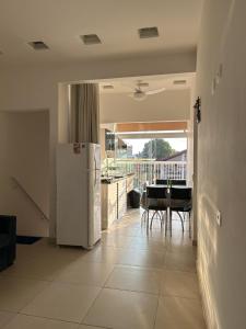 a kitchen with a refrigerator and a table with chairs at Cantinho da Lili in Ubatuba
