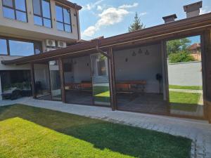 an open patio with glass doors and grass at Къща за гости SUNNY HILL in Varna City