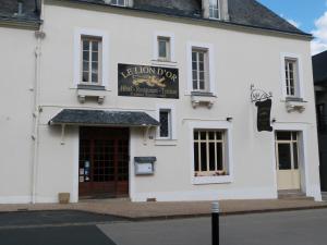 a white building with a sign for a lion door at Le Lion d'Or in Ingrandes