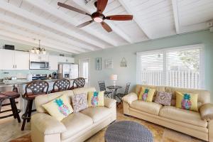 a living room with two couches and a ceiling fan at Key Colony Hide Away in Key Colony Beach