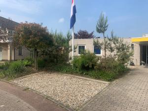 a house with a flag in front of it at Bambou Rooms in Vrouwenpolder