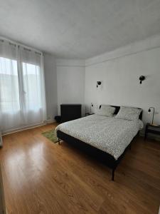 モントルイユにあるMaison spacieuse aux portes de Parisのベッドと木の床のある寝室