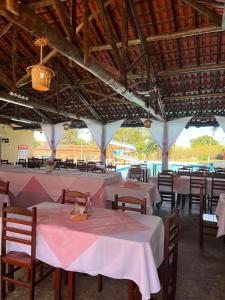 a restaurant with tables and chairs with pink table cloth at Ananda pousada chalé in São Pedro