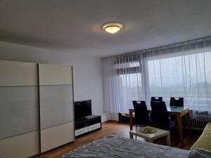 a bedroom with a bed and a table and a television at B1011, gemütliches Appartement mit Ausblick in Lahnstein