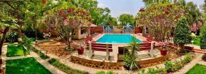 a house with a swimming pool in a garden at Button Eyes Resort - Pet friendly in Hyderabad