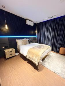 a bedroom with a large bed and a blue wall at Luxury One Bedroom Furnished Apartment in Abuja