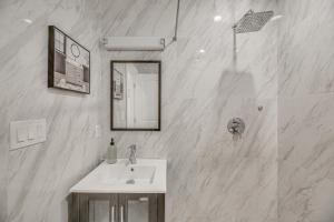 ロサンゼルスにあるEast Los Angeles Retreat about 2 Mi to Citadel Outletsの洗面台と鏡のある白いバスルーム +17枚の写真