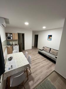 a living room with a table and a couch at Mini Zoo Apartman in Nagykanizsa