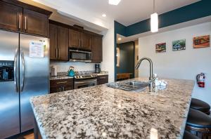 a kitchen with a granite counter top and stainless steel refrigerator at Downunder Mountain Retreat in Revelstoke