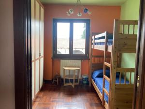 a bedroom with bunk beds and a table and a window at Il Girasole in Bricherasio