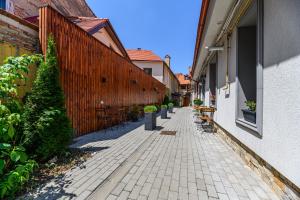 an alley with a fence and a brick sidewalk at Dallure House Boutique Brasov in Braşov