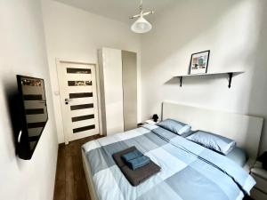 a bedroom with a large white bed with blue pillows at The Garbary - parking free in Bydgoszcz