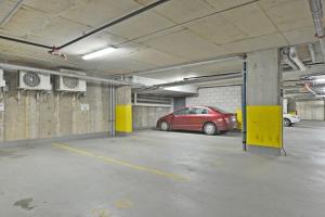 a parking garage with a red car parked in it at L'espace urbain - Parking & Gym in Quebec City +24 photos