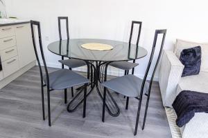 Cormeilles-en-ParisisLe Cocon Cormeillais的玻璃桌和四把椅子 更多2张照片