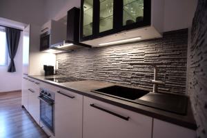 a kitchen with a sink and a brick wall at Flataid PremiumAPART Graz Center in Graz +13 photos