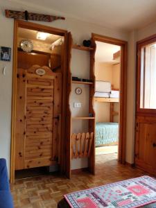 a room with a closet with a refrigerator and a bedroom at Monte Rosa Ski Apartment in Gressoney-Saint-Jean