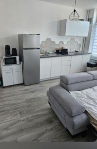 a kitchen with a refrigerator and a couch in a room at Ma location plage dunkerque in Dunkerque