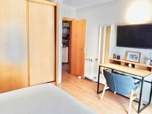 a bedroom with a desk and a bed and a television at Apartmento SOMA Aljezur in Aljezur