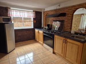 a kitchen with a refrigerator and a stove top oven at Casa Flores de la Montaña in Mineral del Monte
