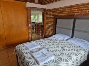 a bedroom with a bed with towels on it at Casa Flores de la Montaña in Mineral del Monte