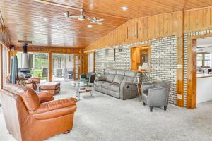 a living room with leather furniture and a brick wall at Spacious Ohio Family Home on 5-Acre Property! in New Philadelphia