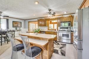 a kitchen with wooden cabinets and a table with chairs at Spacious Ohio Family Home on 5-Acre Property! in New Philadelphia