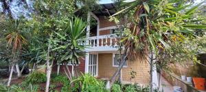 a brick house with palm trees in front of it at Casa Flores de la Montaña in Mineral del Monte