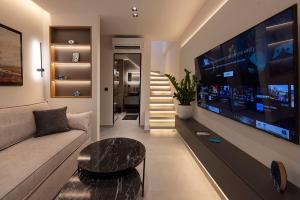 a living room with a couch and a large flat screen tv at Akira Suites in Afitos