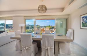 a dining room with a table and chairs and a large window at Ferienvilla für 10 Personen in Sounion in Sounio