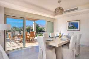 a dining room with a table with white chairs at Ferienvilla für 10 Personen in Sounion in Sounio